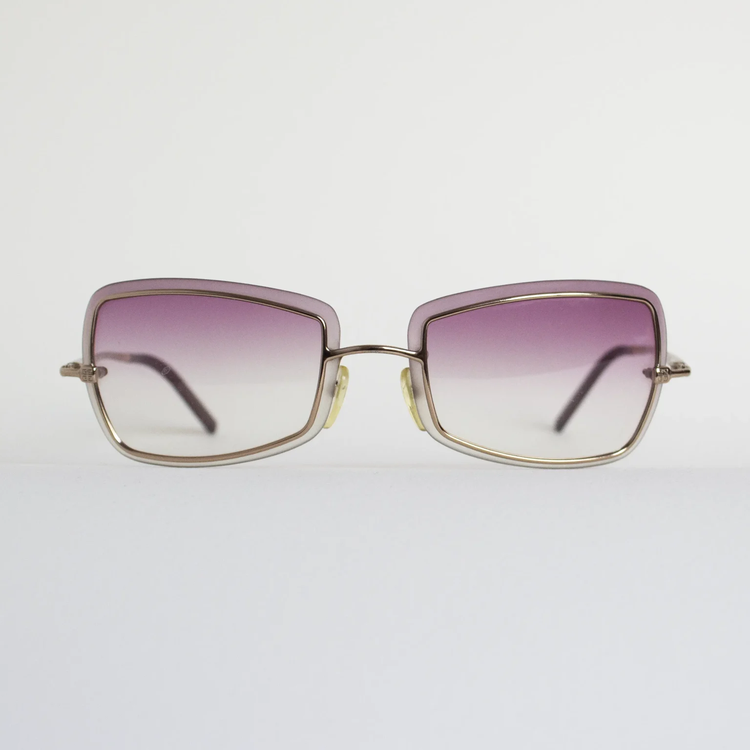 Vista frontal: Gafas vintage Givenchy 006, diseño rectangular en oro rosado con cristales rosa degradados.